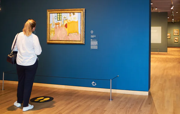 Een vrouw kijkt naar het schilderij De slaapkamer van Vincent van Gogh in de vaste collectie van het museum. Foto: Tomek Dersu Aaron