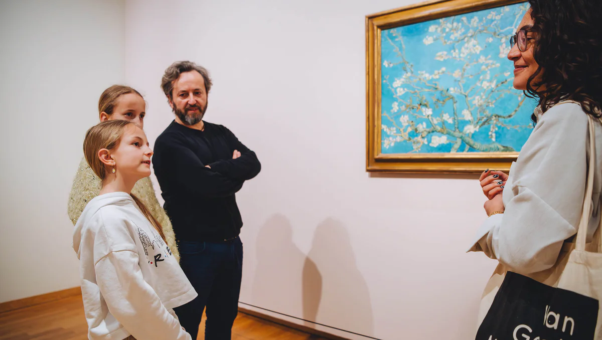 Een gezin krijgt uitleg bij het schilderij Amandelbloesem tijdens een rondleiding in het Van Gogh Museum. Foto: Jelle Draper