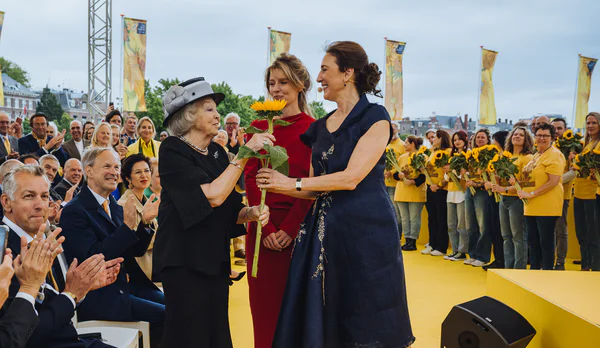 Prinses Beatrix krijgt een zonnebloem uitgereikt door Emilie Gordenker, directeur van het Van Gogh Museum. Foto: Jelle Draper
